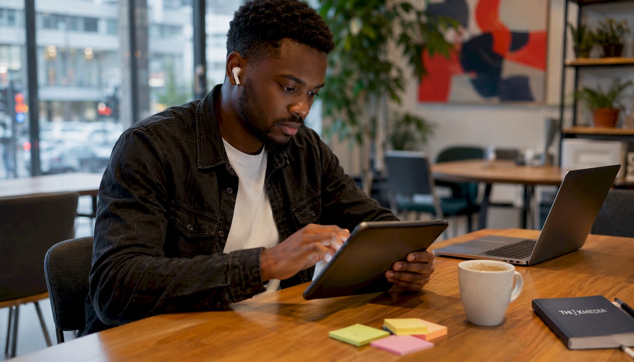Eine Frau nutzt ein Tablet, um sich im digitalen Arbeitsumfeld weiterzubilden.